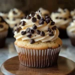 Freshly baked chocolate chip cupcakes on a cooling rack.