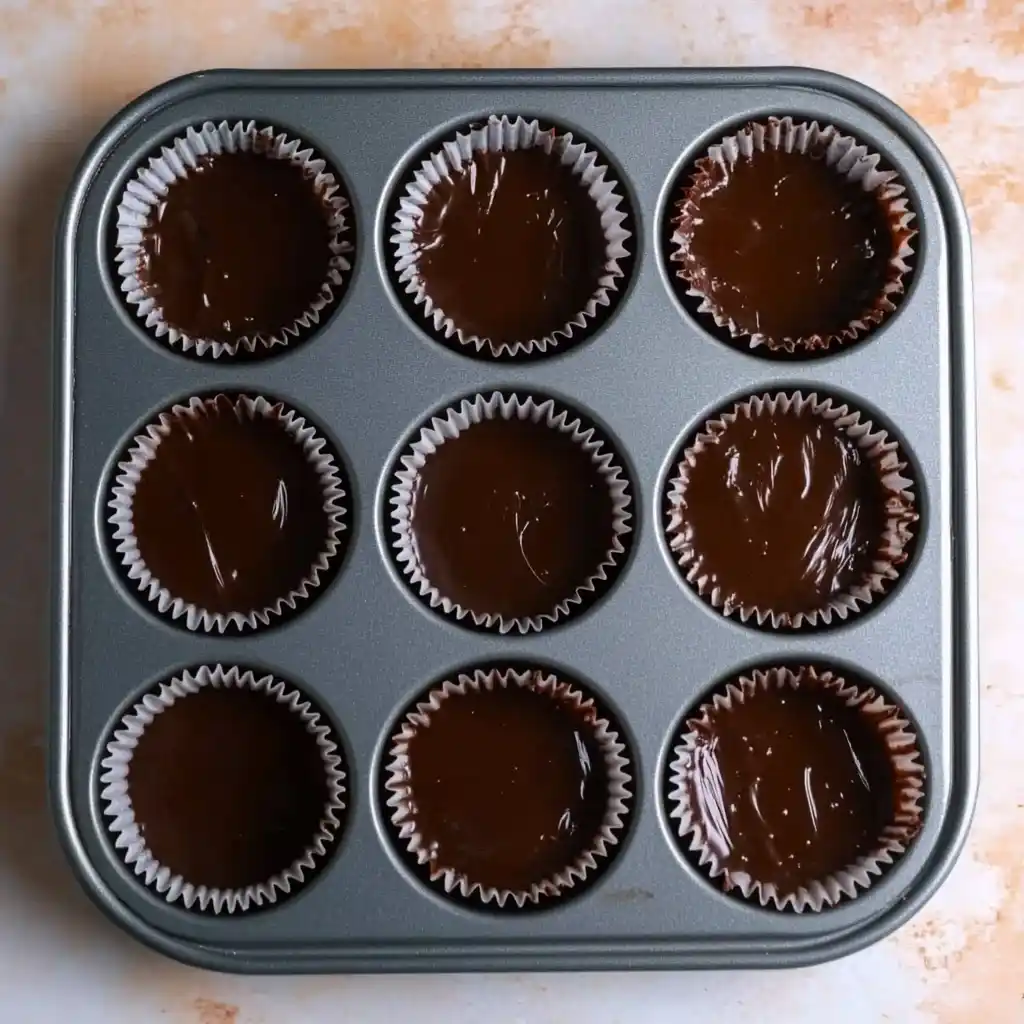 Filling cupcake liners with chocolate fudge batter