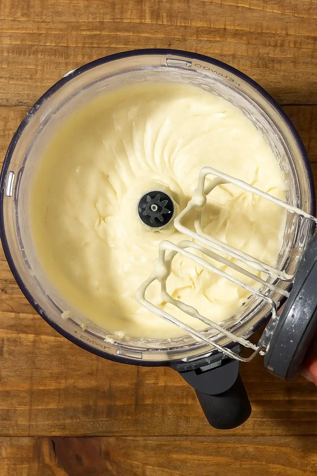 Whipping dairy-free cream cheese frosting in a mixing bowl.