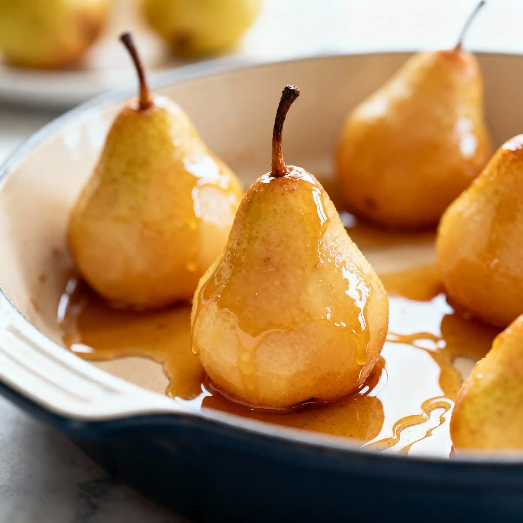 pears in baking dish drizzled with maple syrup before baking