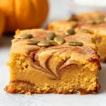 Pumpkin Snickerdoodle Blondies with a cinnamon sugar crust cooling on parchment paper.
